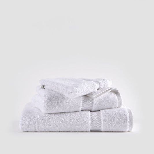 Ensemble de serviettes en bambou blanc empilées montrant serviettes pour le visage, les mains et bain avec bandes texturées.