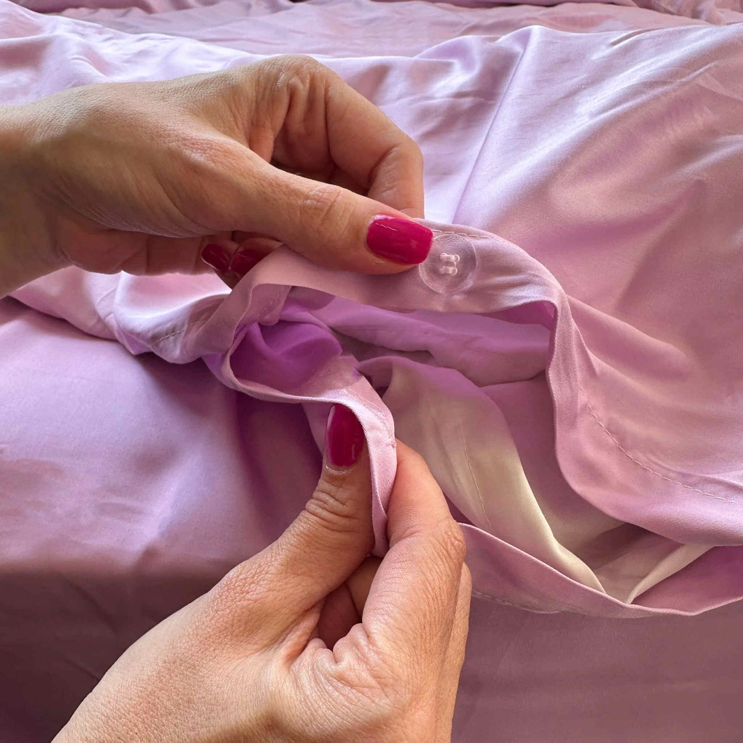 Close-up of pink bamboo duvet cover buttons being fastened – high-quality, soft and sustainable fabric