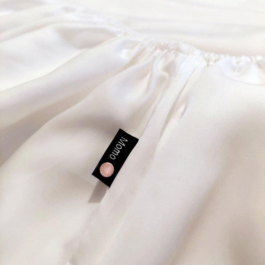 Drap-housse blanc en bambou avec étiquette de marque momo-cotton sur le tissu plié