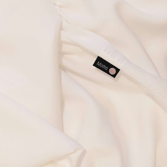 Gros plan de l'étiquette sur drap en bambou blanc nacré – literie douce, respirante et durable