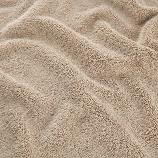 Ensemble de serviettes en bambou beige montrant la texture douce des serviettes de visage, main et bain