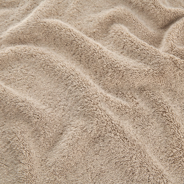 Ensemble de serviettes en bambou beige montrant la texture douce des serviettes de visage, main et bain