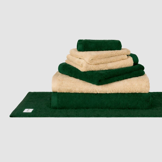Stacked green and cream Wabi Sabi towel set by Momo Cotton displayed on neutral background