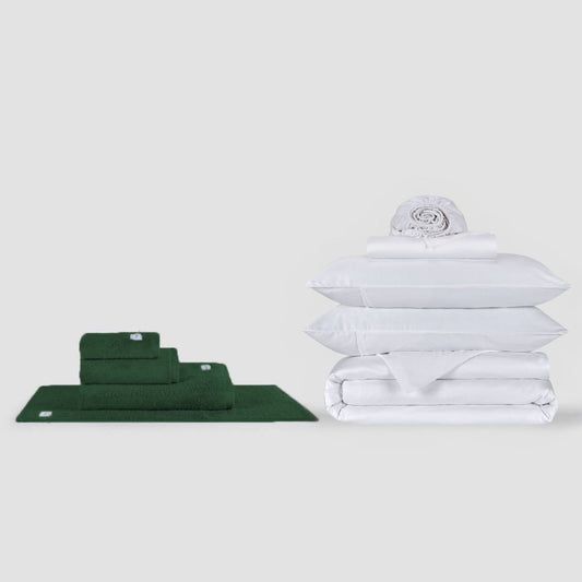 Ensemble de serviettes vertes et ensemble de draps blancs empilés sur fond blanc par Momo Cotton