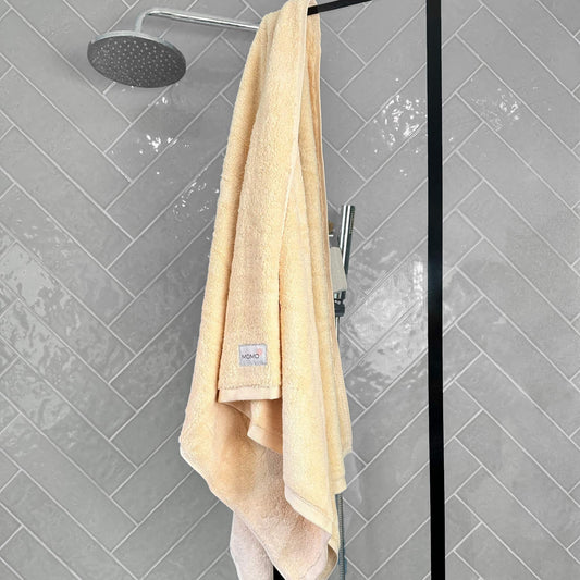 Beige bamboo bath towel on grey background – soft, absorbent and sustainable