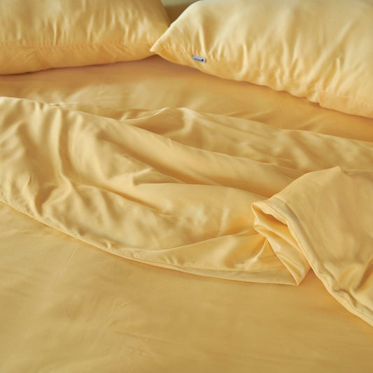 Jogo de capa de edredão em bambu creme exibido na cama mostrando textura de tecido macio e sedoso e cor bege natural