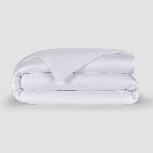 Housse de couette blanche pliée présentant la texture douce du tissu bambou 100% avec boutons cachés en bas