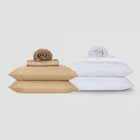 Momo Cotton beige and white sheet sets stacked with rolled bedding and pillows on neutral background