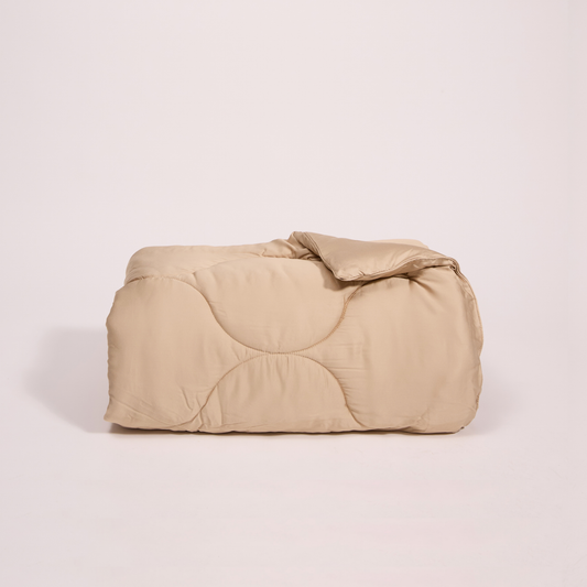 Edredão bege 2-em-1 meia estação dobrado sobre fundo branco, vista frontal